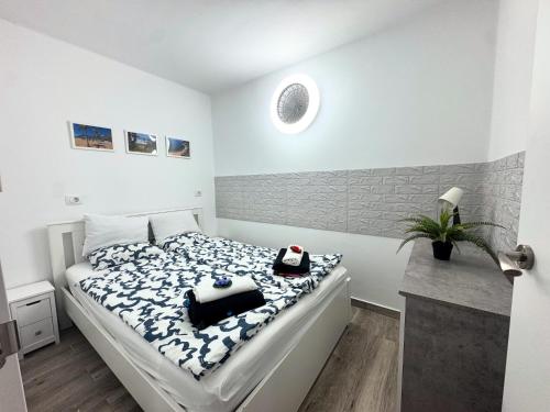 a bedroom with a bed with a blue and white comforter at Sissy Tenerife Apartman in San Miguel de Abona