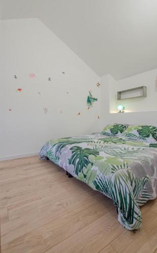 a bedroom with a bed with a green comforter at les piafs du der 1 in Joncreuil