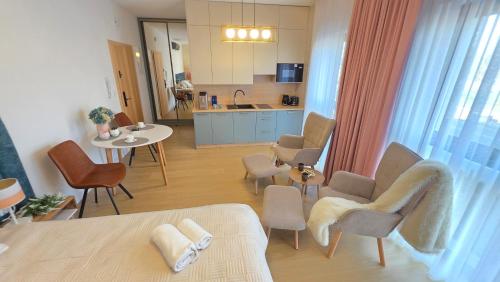 a kitchen and living room with a table and chairs at Boszkowo Horizon Park Apartament 14 "Laguna" in Boszkowo