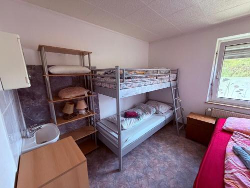 a bedroom with two bunk beds and a sink at Gästehaus Nachtigall in Gädheim