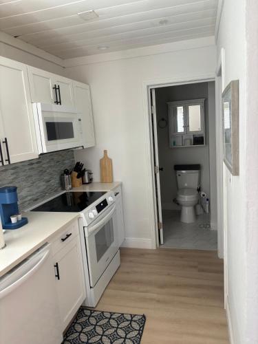 a kitchen with white cabinets and a toilet at Seaside Retreat Cottages #4 in Clearwater Beach