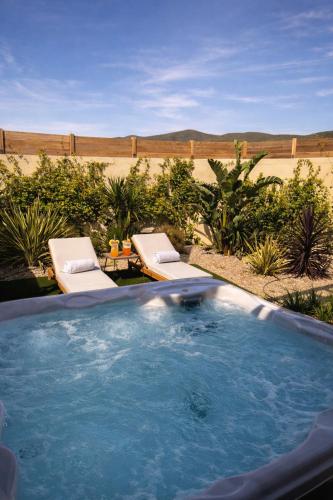 a large swimming pool with two lounge chairs in a desert at Residence I Pozzi in Belgodère