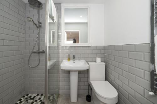 a white bathroom with a sink and a toilet at Abbey View Coach House in Youghal