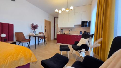 a room with a bed and a kitchen and a living room at Boszkowo Horizon Park Apartament 15 "Bordowy" in Boszkowo