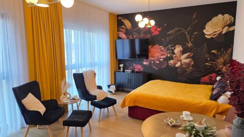 a bedroom with a yellow bed and chairs and a table at Boszkowo Horizon Park Apartament 15 "Bordowy" in Boszkowo