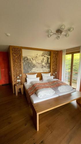 a bedroom with a large bed and a painting on the wall at Neumaier's Hotel in Biberach bei Offenburg