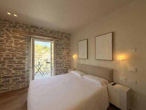 a bedroom with a large white bed and a window at Le Terrazze sul Fiume in Santa Sofia