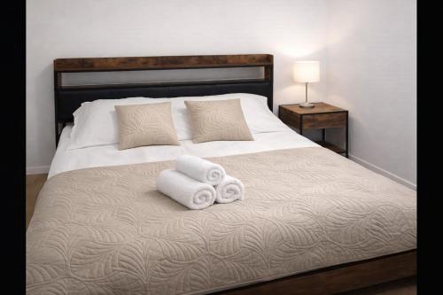 a bed with two towels and two pillows on it at PikApart in Olsztyn