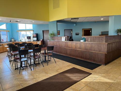 a restaurant with a bar with chairs and a counter at Days Inn by Wyndham Sault Ste Marie MI in Sault Ste. Marie