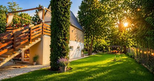 a house with a green yard next to a building at Richland Ráckeve in Ráckeve