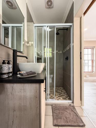 a bathroom with a shower with a sink and a shower at The Gables-Clarens in Clarens