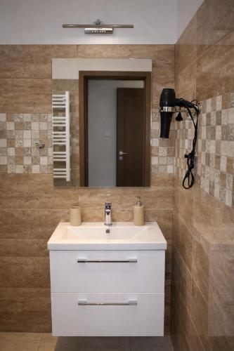 a bathroom with a white sink and a mirror at Sódomb vendégház in Egerszalók