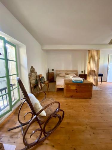 a living room with a chair and a bed at Joli Studio Dépendance Lectoure Intra-muros in Lectoure