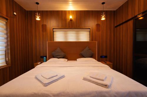 a bedroom with a large bed with two towels on it at The VARKALA HAVEN 105 in Varkala