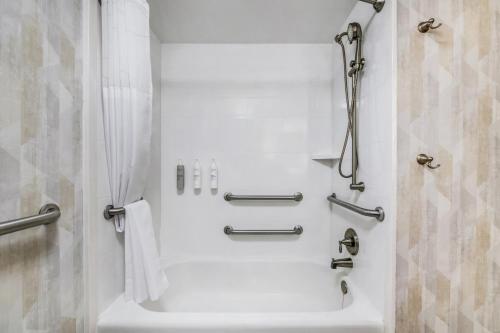 a white bathroom with a shower and a bath tub at Hampton Inn Milledgeville in Milledgeville
