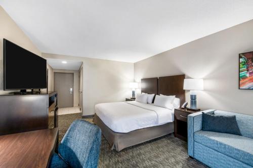 a hotel room with a bed and a tv at Hampton Inn Milledgeville in Milledgeville