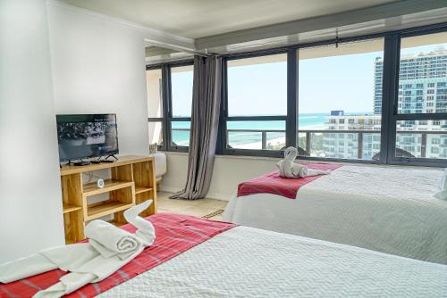 a bedroom with two beds and a large window at Oceanview Apartment on the beach 123 in Miami Beach