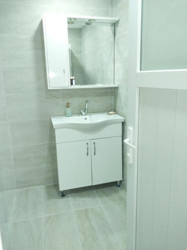 a white bathroom with a sink and a mirror at Jasmin Apart Otel in Göcek
