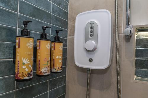 a soap dispenser with three bottles in a bathroom at Narrow Water Lodges in Cornamucklagh