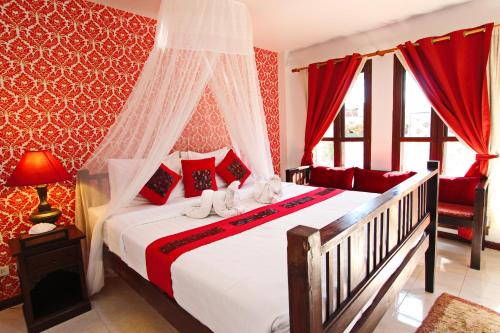a bedroom with a large bed with red walls at Shewe Wana Boutique Hotel in Chiang Mai
