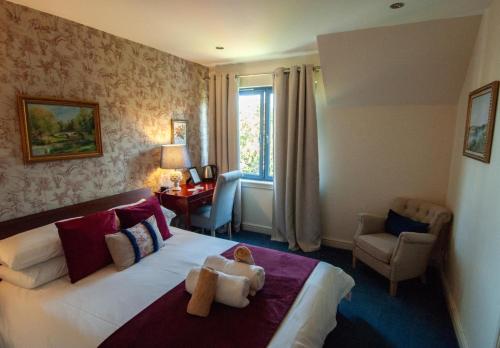 a bedroom with a bed with a teddy bear on it at Suardal Guest House in Fort Augustus