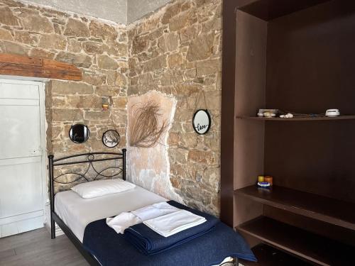 a bedroom with a bed and a stone wall at Anthemis home II in Agios Kirykos