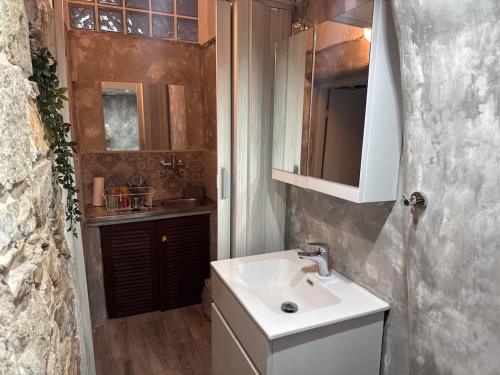 a bathroom with a white sink and a mirror at Anthemis home II in Agios Kirykos