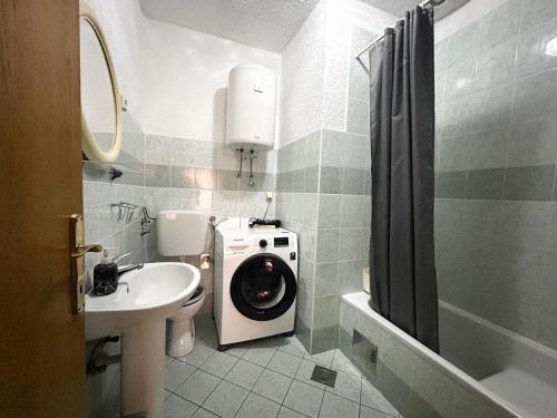 a bathroom with a washing machine and a sink at Guest House Angela in Senj