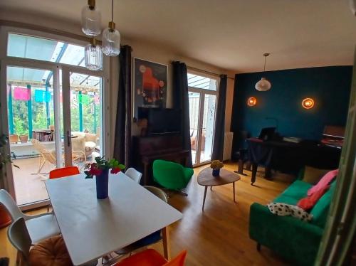 a living room with a white table and a couch at Cyrus House - maison complète 90m2 in Le Mans