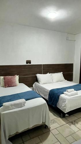 two beds in a hotel room withthritisthritislictslictslicts at Pousada Refúgio Do Cangaço in Piranhas