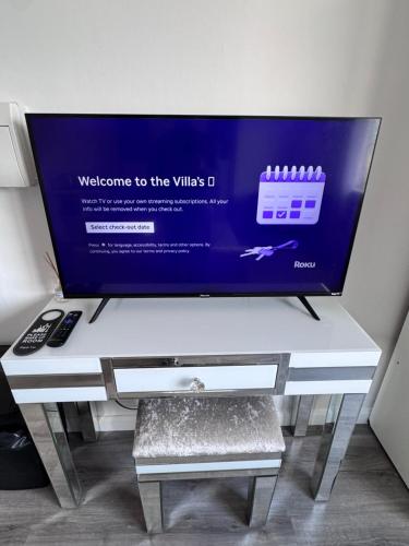 a flat screen tv sitting on top of a table at The Villas in Rock Ferry