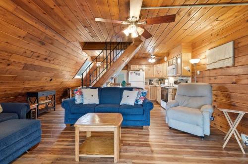 a living room with blue couches and a ceiling fan at Chalet #44 in Stevensville