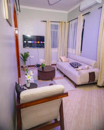 a living room with two couches and a table at JIV Luxury Homes in Mwanza