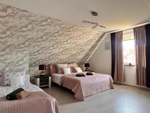 a bedroom with two beds and a stone wall at Emilia domki U Przyjaciół in Żarnowska
