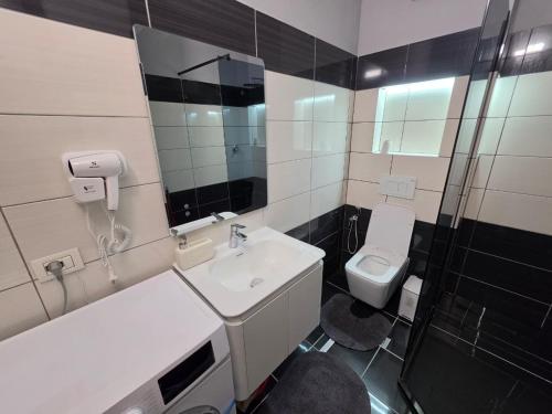 a bathroom with a sink and a toilet and a shower at Apartment N6 Shkoder in Shkodër