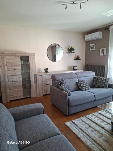 a living room with two couches and a mirror at BERGERAC Chez Béa in Bergerac