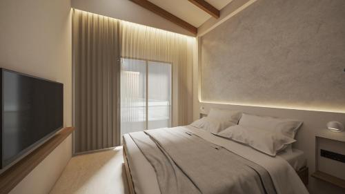 a bedroom with a large bed and a television at NOEMA Fanari in Fanari