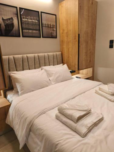 a bedroom with a white bed with towels on it at Lounetta Apartments 1 in Missolonghi