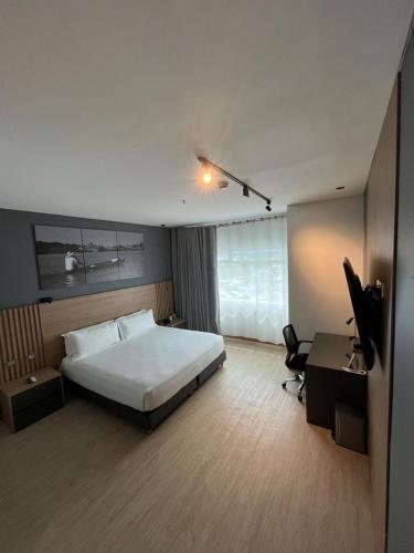 a bedroom with a bed and a desk and a chair at Hotel San Silvestre in Barrancabermeja