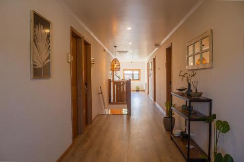 a hallway with wooden floors and white walls and wooden floorshiba at Hotel Los Ríos in Panguipulli