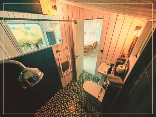 a small bathroom with a sink and a toilet at La Pause En Soi - Cabanes climatisées avec Jaccuzi privatif en option in Ponlat-Taillebourg