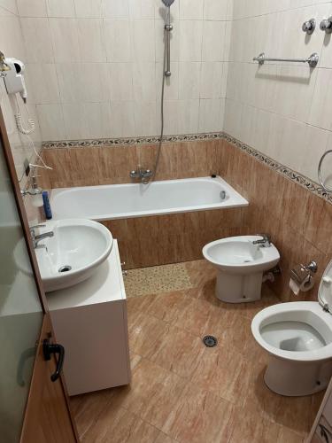 a bathroom with a tub and a toilet and a sink at Kruja Grande Hotel in Krujë
