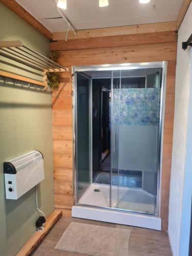 a glass shower in a room with a fan at de Tweelingen in Schoonloo