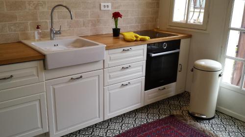 a kitchen with white cabinets and a sink and a window at Bastide Philomen in Pérols