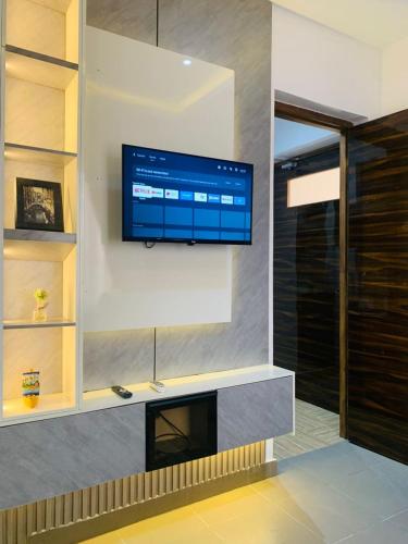 a living room with a flat screen tv on a wall at Luxury Studio Apartment in Ilado