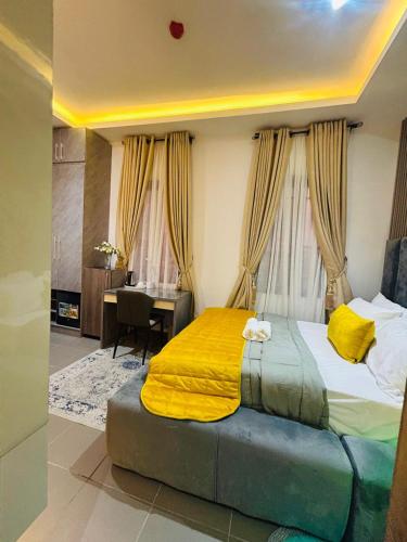 a bedroom with a bed with yellow sheets and a desk at Luxury Studio Apartment in Ilado