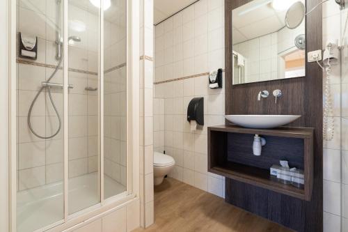 ein Badezimmer mit Waschbecken und Dusche in der Unterkunft Hotel Ameland in Nes