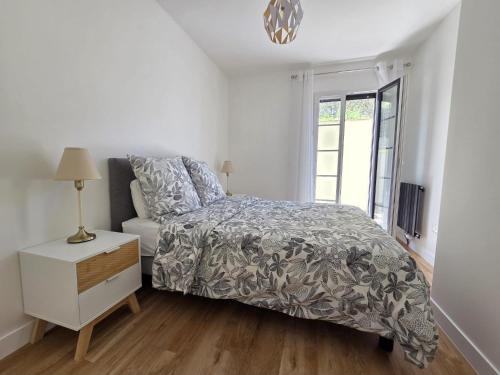 a white bedroom with a bed and a window at Appartement Dora in Villiers-sur-Marne