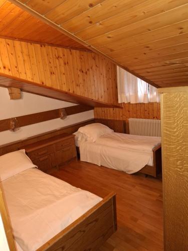 two bunk beds in a room with wooden ceilings at Campiglio Trilocale Monte Spinale in Madonna di Campiglio