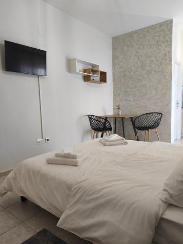 a bedroom with a large bed with two chairs and a table at Lounetta Apartments 2 in Missolonghi